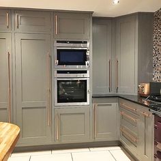 a kitchen with gray cabinets and stainless steel appliances