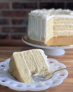 a slice of white cake on a plate with a fork in front of the cake