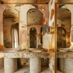 an old bathroom with two sinks and three mirrors in it's walls, covered in peeling paint