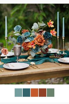 the table is set with candles, plates and vases filled with different colored flowers