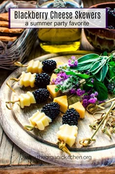 blackberry cheese skewers on a wooden platter with herbs and blackberries in the background