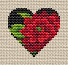 a cross stitched heart with flowers in the shape of a red rose on it