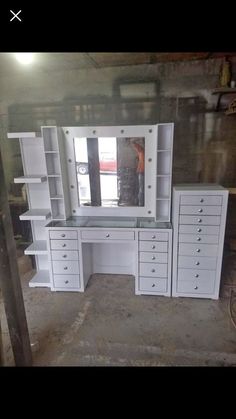 a white desk with lots of drawers and a mirror on it's side in a room under construction