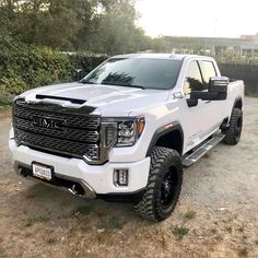 a white truck parked on top of a dirt field