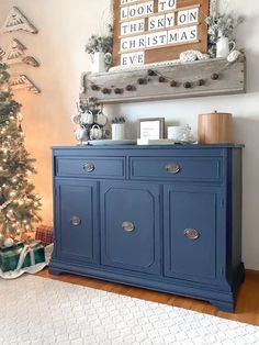 a blue dresser in front of a christmas tree