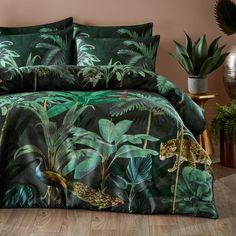 a bed covered in green leaves with a leopard and other animals on the coverlet