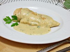 a white plate topped with chicken covered in gravy