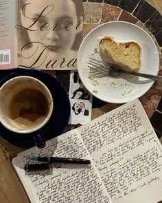 there is a piece of cake next to a cup of coffee and an open book