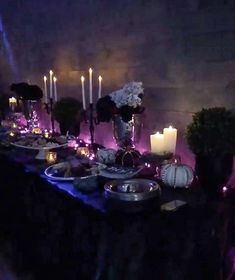 a long table with candles and plates on it