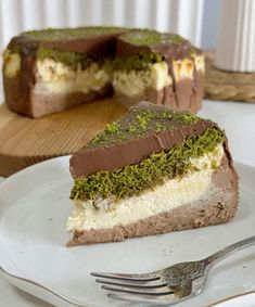 a piece of cake on a white plate with a fork next to it and another slice in the background