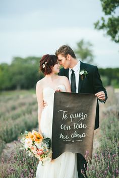 a bride and groom holding a sign that says, te quiero con toda di ama