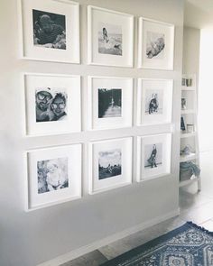 a white wall with many black and white pictures on it