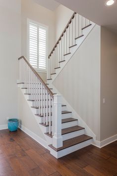 a white staircase with wooden floors in a house