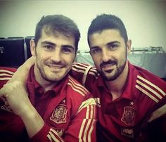 two men in red shirts posing for the camera with their arms wrapped around each other