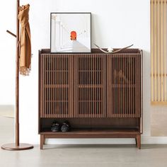 a wooden cabinet sitting next to a coat rack