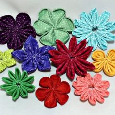 six different colored flowers with polka dots on the top and one flower in the middle