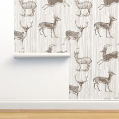 a curtain with deers drawn on it in front of a white wall and wooden floor