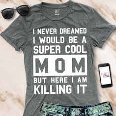 "\"I NEVER DREAMED I WOULD BE A SUPER COOL MOM, BUT HERE I AM KILLING IT\" Unisex Fit T-Shirt - Pick Color Makes a great Mother's Day Gift! These run on the larger side for women, as they are a unisex fit. We recommend ordering a size down if you prefer a fitted shirt style. Color: Black, or Gray Sizes: XS, S, M, L, XL, XXL Cotton & Polyester Blend Very Soft and Comfortable Cotton/Poly Blend If you are looking to do a custom order in this style, please feel free to message us. *photo props n Mom Sayings For Shirts, Widowed Mom, Cool Mom Shirt, Mom Clothes, Mom Graphic Tees, Mother Shirts, Call Mom, Sport Shirts, Etsy Ideas