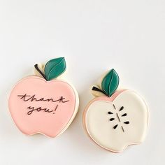 two decorated cookies with the words thank you and an apple shaped cookie in the middle