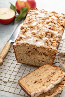 a loaf of bread sitting on top of a cooling rack next to an apple slice