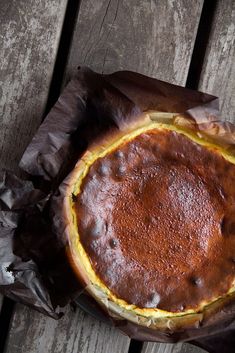 a close up of a pie on a wooden table with the words baque cheesecake