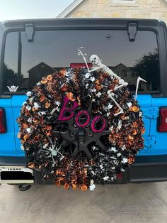 a car with a wreath on the back of it that says boo in pink and black