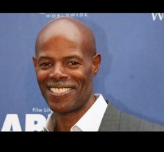 a smiling man in a gray suit and white shirt