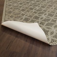 an area rug is laying on the floor in front of a wooden flooring surface