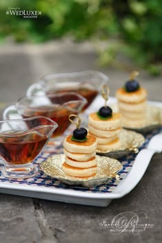 small desserts are arranged on a plate with tea