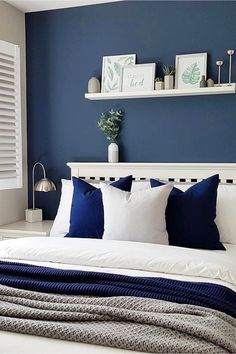 a bedroom with blue walls and white bedding