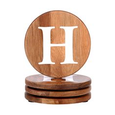 three wooden coasters with the letter h on them, stacked in front of each other