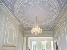 an ornately decorated room with chandelier and fireplace