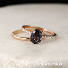 two gold wedding rings with an oval cut brown diamond on the side and white diamonds around them