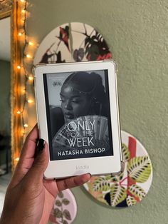 a person holding up a book in front of a mirror