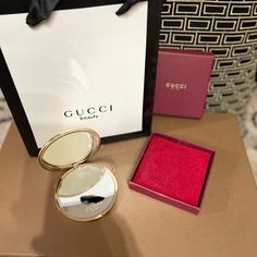 a gucci box and its contents on a table in front of a purse bag