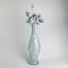 a glass vase with flowers in it on a white background and the bottom half is empty