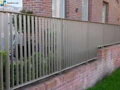 a metal fence on the side of a brick building