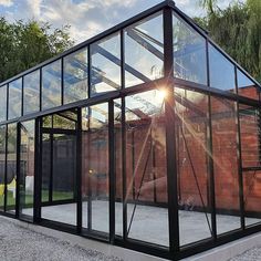 a large glass building with the sun shining through it