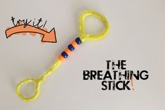 a pair of scissors with the words the breathing stick written on one side and an orange toothpick in the other