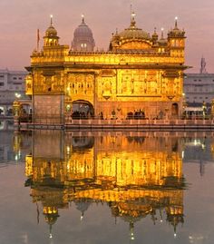 the golden building is reflected in the water