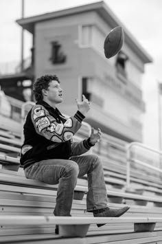 a man is sitting on the bleachers and throwing a frisbee in the air