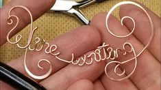 a person holding a pair of scissors with the word love spelled in cursive writing