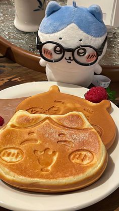 a white plate topped with pancakes next to a stuffed animal