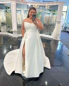 a woman in a white dress taking a selfie