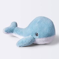 a blue whale stuffed animal laying on top of a white surface