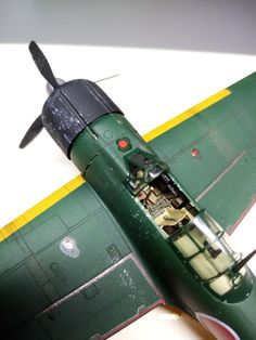 an old model green airplane on a white surface