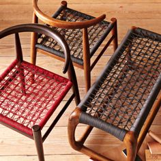 two chairs sitting on top of a wooden floor next to each other with red seats