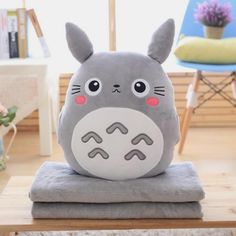 a gray totoro pillow sitting on top of a table