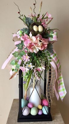 a vase filled with flowers and eggs on top of a table