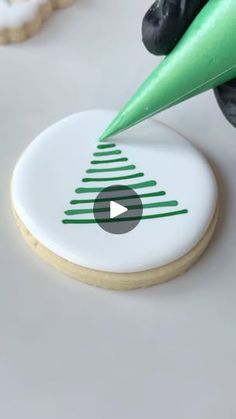 a cookie being decorated to look like a christmas tree with a green marker on it